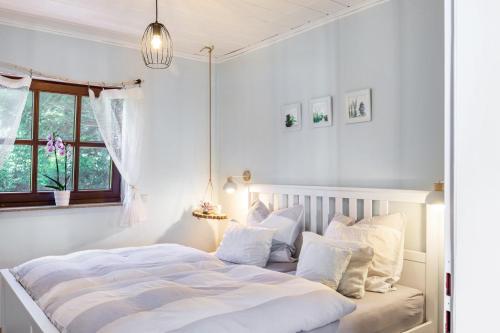 a white bedroom with a bed with white pillows at Cottage in Schlangenbad in Schlangenbad