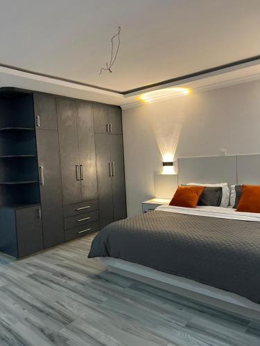 a bedroom with a bed and a dresser and cabinets at Noble Park Apartment in Kiserian