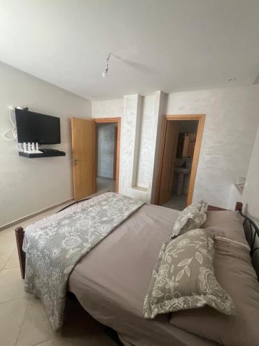 a bedroom with a bed and a tv on the wall at Florida Waves in El Jadida