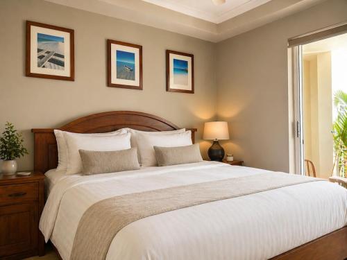 a bedroom with a large white bed with two pictures on the wall at Sundown terrace in North Fremantle