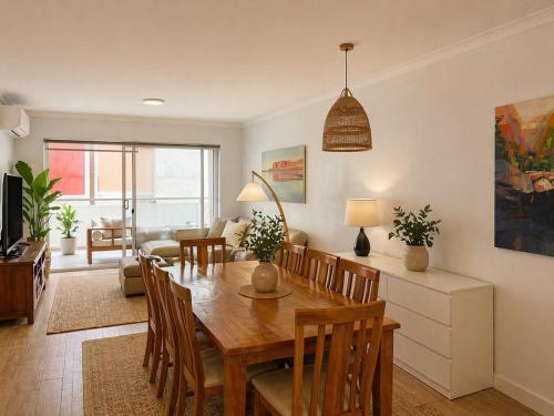 a dining room and living room with a table and chairs at Sundown terrace in North Fremantle