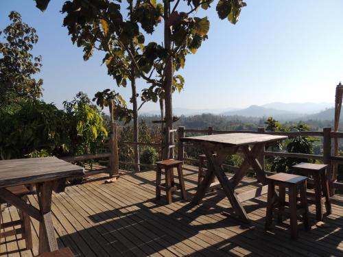 a picnic table and chairs on a wooden deck at Khunyuam Resort in Ban Khun Yuam
