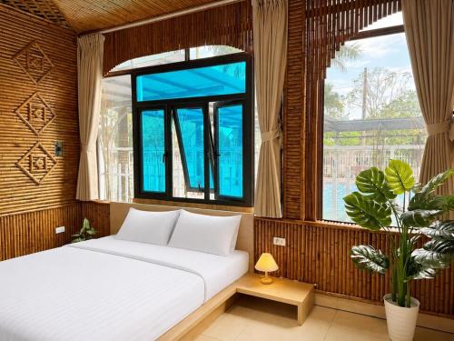 a bedroom with a white bed and a window at Palette Sunset Garden Tam Coc in Ninh Binh