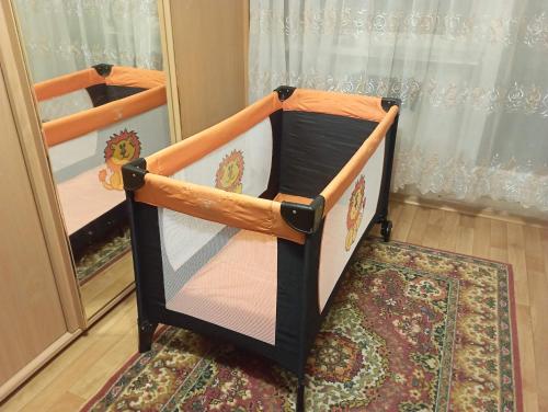 a baby crib in a room with a mirror at A comfortable room with balcony in Tallinn