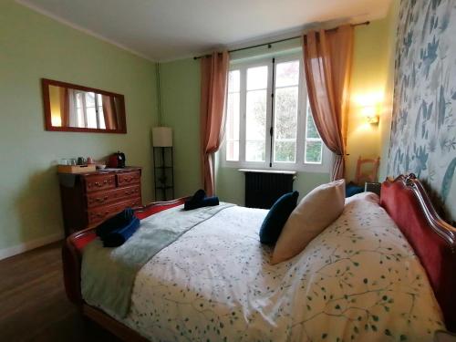 a bedroom with a bed with pillows and a window at Trecastle Chambre d'Hôtes in Châlus