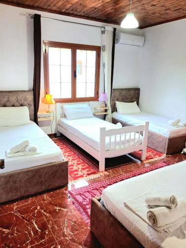 a room with three beds in a room at Villa Rexho in Berat