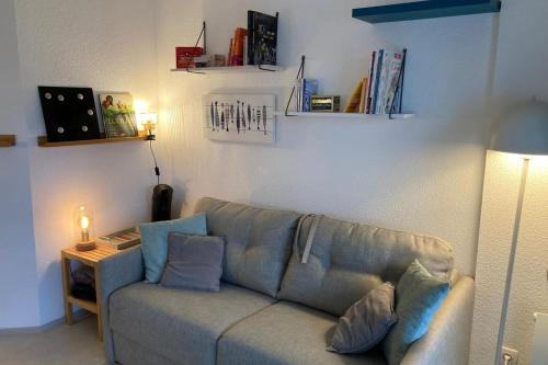 a living room with a couch and a table at Pool and beach studio in Quiberon