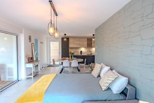 a bedroom with a blue bed and a kitchen at LE JOLI BOIS in Colroy-la-Roche