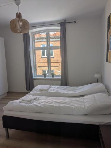 a bed in a room with a window at Stubbekøbing City View Stopover in Stubbekøbing