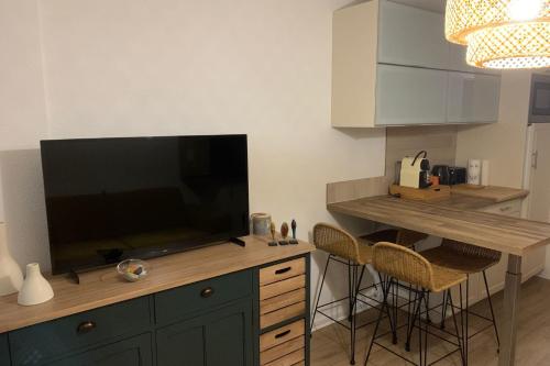 a kitchen with a large flat screen tv on a counter at Apartment with pool and beach access 2 No 31 in Quiberon
