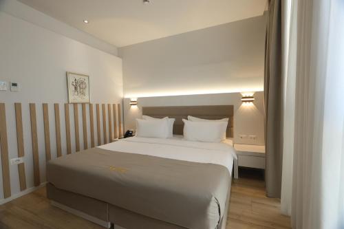 a bedroom with a large white bed with white pillows at Metro Hotel Terminal in Tirana