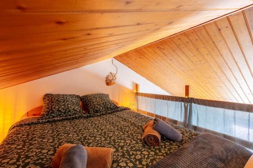 a bed in a room with a wooden ceiling at Le Refuge des Embruns - Port & plages - 4 pers - Tout confort et équipé in LʼHerbaudière
