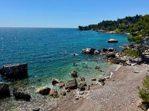 a beach with rocks and the ocean on a clear day at Beachfront Luxury Villa - Bar in Bar