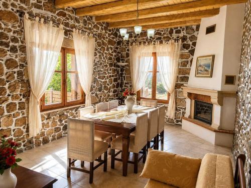 a dining room with a table and a stone wall at Villa Maria Christina with Private Pool in Crete in Skoúrvoula