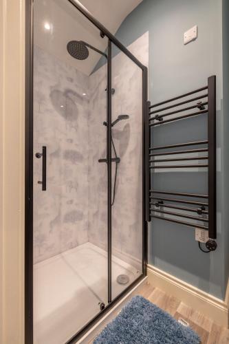 a shower with a glass door in a bathroom at Boutique Stays at 78 in Bangor