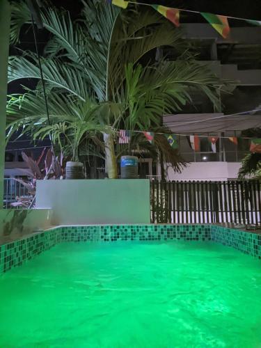 a pool with green water in a building with palm trees at El coltejeriano in Coveñas