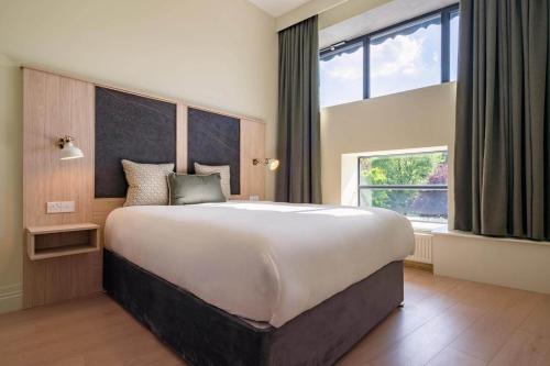 a large bed in a room with a large window at The Malt Store in Birr
