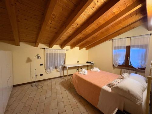 a bedroom with a bed in a room with wooden ceilings at Hotel Adria & Resort in Toscolano Maderno