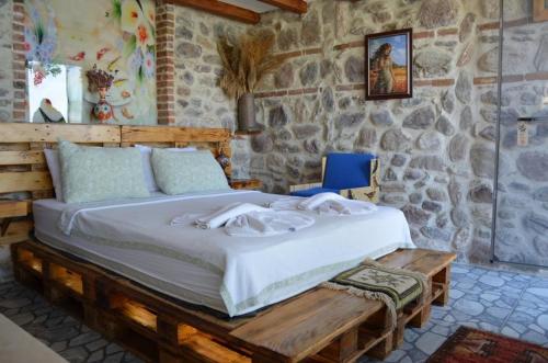 a bedroom with a large bed in a stone wall at Çökertme Butik Otel in Çökertme