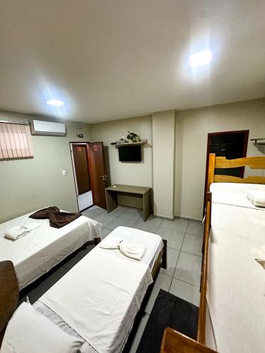 a hospital room with two beds and a table at Hotel Caeté in Bragança