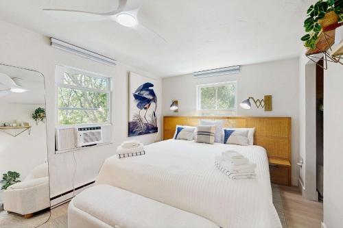 a white bedroom with a large bed and a couch at Moon Tide - Bayside Beach Access & Parking in Provincetown