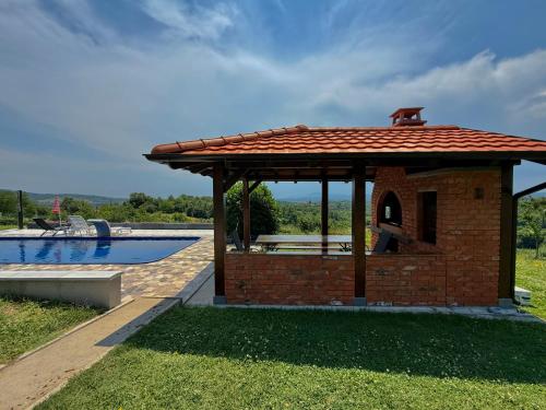 a brick pavilion with a swimming pool in a yard at Kosmaj-Suncani Breg in Drlupa
