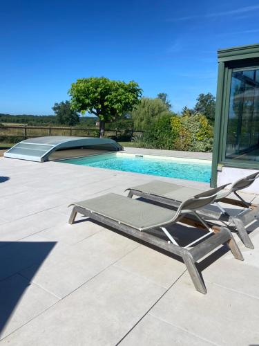 a lounge chair sitting next to a swimming pool at Le Refuge de Bourgogne in Poisson