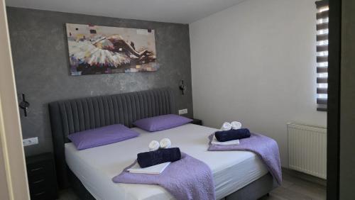 a bedroom with a bed with purple towels on it at Apartman Koko with private jacuzzi in Makarska