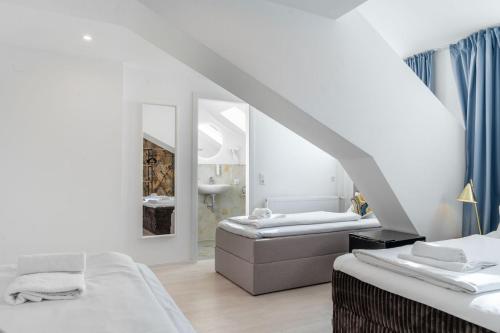 a white room with two beds and a mirror at Villa Vaicun - Boutique Rooms in Lörrach