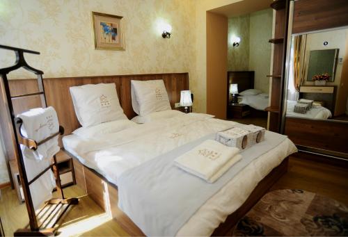 a bedroom with a large bed with white sheets and towels at Hotel Sanapiro Tbilisi in Tbilisi City