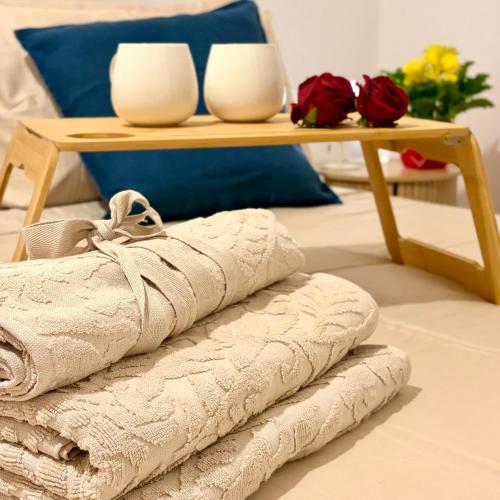 a table with two white vases and a table with towels at UrbanSuite Torino in Turin