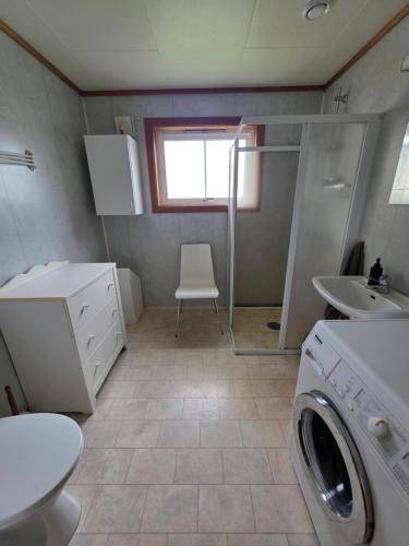 a bathroom with a washing machine and a sink at Rom 4 i bufellesskap in Sogndal