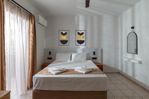 a bedroom with a bed with two towels on it at Sunny Vibes by Estia Adults Only in Stalís