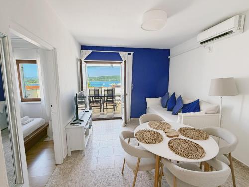 a living room with a table and a couch at Family Apartments Monika - sea view - heated pool II in Punat