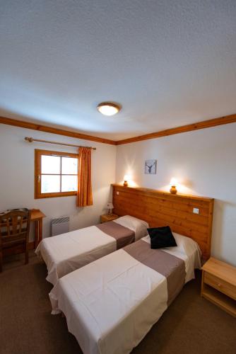 a hotel room with two beds and a window at LesChalets de Pré Genty in Oz