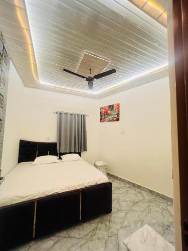 a bedroom with a bed with a ceiling fan at m m residency in New Delhi