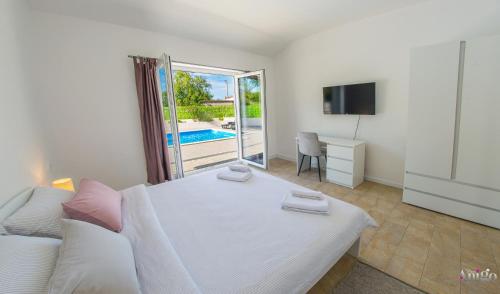 a bedroom with a bed and a tv and a couch at Kuća za odmor Veronika in Klobuk