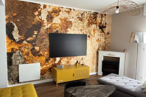 a living room with a tv on a wall at Maison proche centre ville in Quiberon