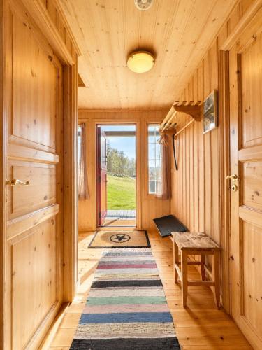 a hallway with a rug and a table and a door at Cottage Yard - cozy Cabin in Geilo