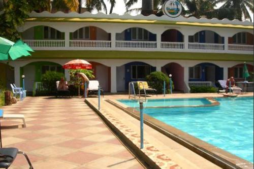 a hotel with a swimming pool in front of a building at Williams Beach Retreat in Colva