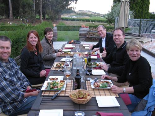 um grupo de pessoas sentadas à volta de uma mesa a comer em Ugbrooke Country Estate em Lower Dashwood