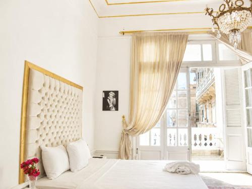 a white bedroom with a bed and a window at New palace court in Cairo