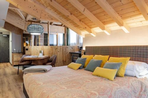 a bedroom with a large bed with yellow pillows at Hotel Concordia in Livigno