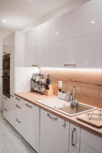 a white kitchen with white cabinets and a sink at Villa Gallera - Slovak Paradise in Dravce
