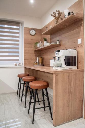 a kitchen with a counter with stools and a microwave at Villa Gallera - Slovak Paradise in Dravce