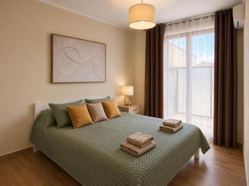 a bedroom with a bed with two towels on it at Adriatic Monte Apartments in Tušupi