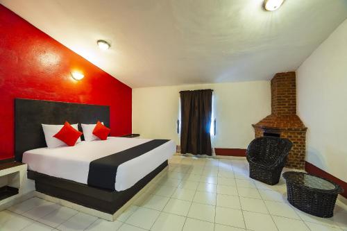 a hotel room with a bed and a fireplace at Capital O Hotel Meson Del Rio, Tepotzotlan in Tepotzotlán