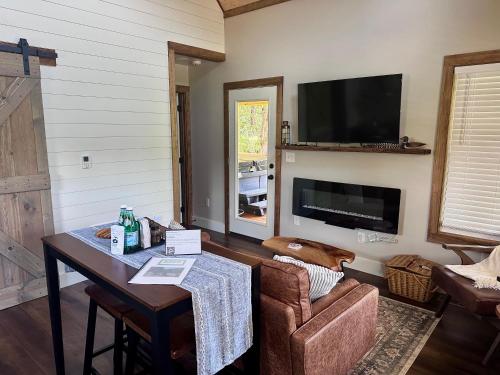 a living room with a table and a tv at By the Docks Knox in Knoxville