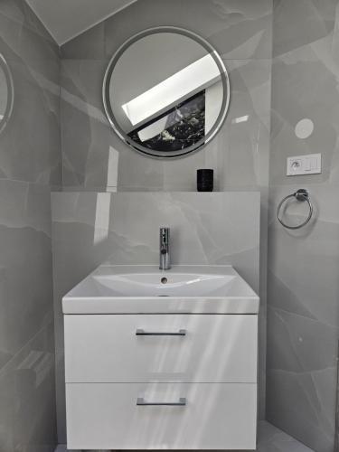 a bathroom with a white sink and a mirror at Penzión ANTRACIT in Štúrovo