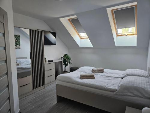 a bedroom with a bed and two skylights at Penzión ANTRACIT in Štúrovo